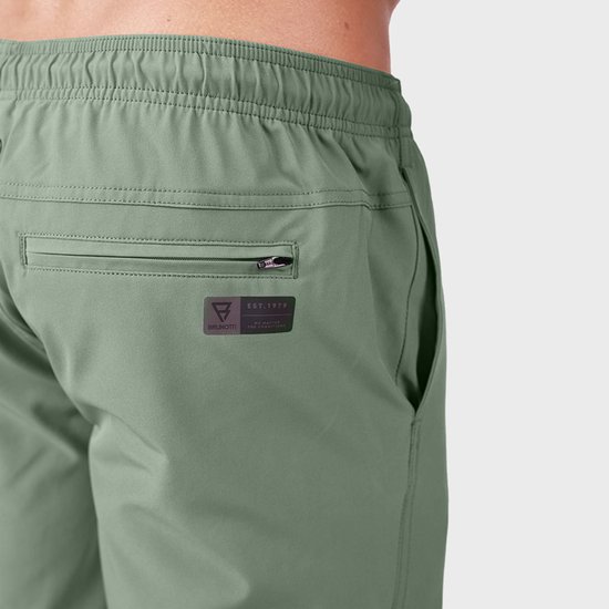 Arrière d'un maillot de bain vert clair avec poche zippée, logo de la marque et 'EST. 1979'.