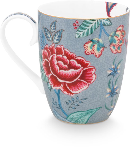 Witte mok met rode en blauwe bloemenprint op een grijze achtergrond.