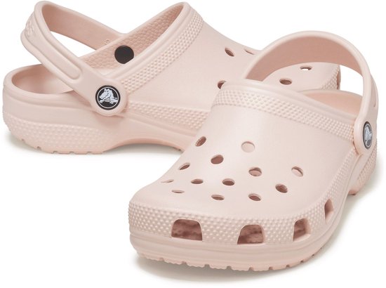 Lichtroze Crocs Classic Clogs, de ene achter de andere, met draagband om de enkel.