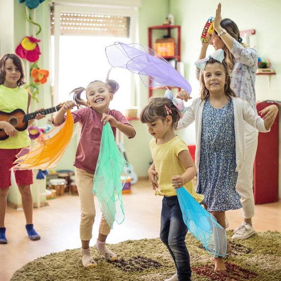 Kinderen met gekleurde sjaals in een klaslokaal; een meisje met oranje en groene sjaals, een ander met paarse.