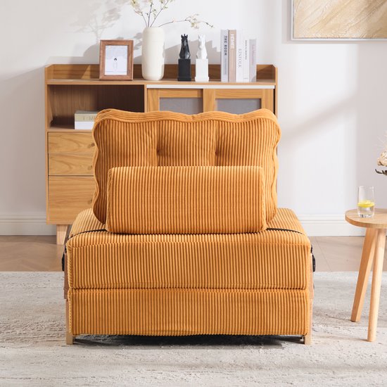 Oranje corduroy slaapfauteuil dichtgeklapt, met twee kussens, waarvan één wigvormig.