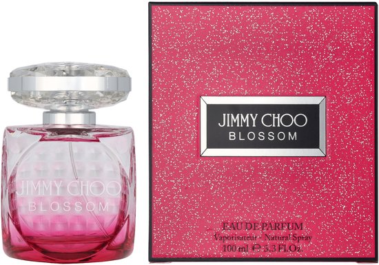Jimmy Choo Blossom Eau de Parfum damesparfum in een roze glazen fles met kristallen dop, naast de roze, glinsterende verpakking.