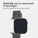 Groen corduroy horlogebandje met zilverkleurige gesp, bevestigd aan een smartwatch.