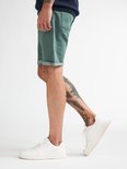 Groene denim shorts met omgeslagen zoom, gedragen door een man met tatoeages.