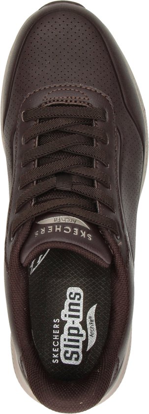 Bovenkant van een bruine Skechers sneaker met veters, perforaties en de tekst "Slip-ins Arch Fit".