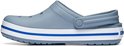 Zijaanzicht van een grijze Crocs clog met een witte en blauwe streep op de zool.