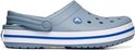 Zijaanzicht van een grijze Crocs clog met het Crocs logo op de zijkant en een blauwe en witte streep op de zool.