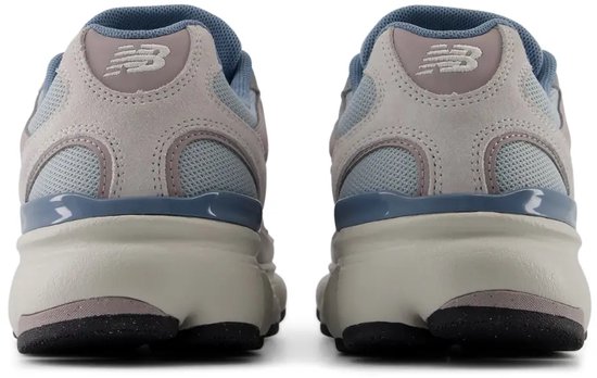 Achterkant van lichtgrijze, blauwe en roze New Balance sneakers. Zichtbaar New Balance logo op de hiel.
