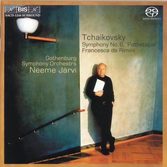 Een man in pak staat voor een muur met Tchaikovsky: Symphony no. 6 'Pathetique' Francesca da Rimini.