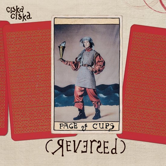 Tarotkaart met Page of Cups (Omgekeerd), afgebeeld met maliënkolder, rode mouwen en een vis in een beker.