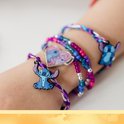 Armbandjes met vlechttechniek, kleurrijke kralen en Stitch-bedels om een pols.
