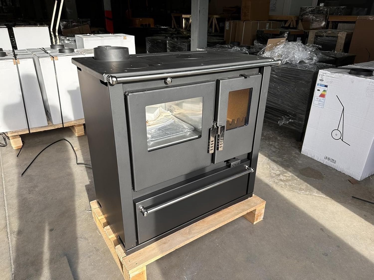 Houtkachel Verso Cs Plus Inox Links heeft een vermogen van 7,7 kW, groot bakvak en robuust roestvrij stalen design