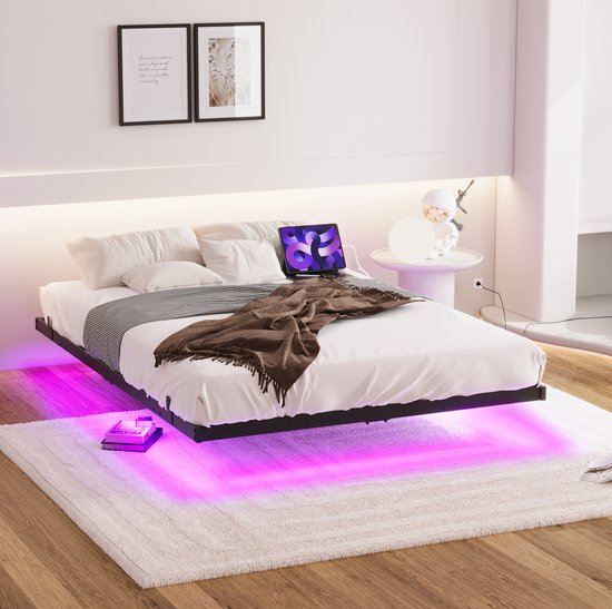 Opgemaakt tweepersoonsbed met paarse LED-verlichting onder het frame in een moderne slaapkamer.