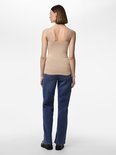 Achteraanzicht van een model in een beige hemdje met kanten bandjes en blauwe jeans.
