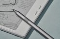 Grijze BOOX styluspen op een witte e-reader.