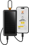 Zwarte Xtorm powerbank met zonnepaneel, karabijnhaak en LED indicatoren, naast een smartphone die 42% oplaadt in 30 min.