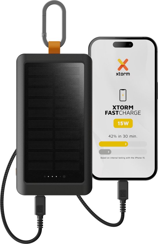 Zwarte Xtorm powerbank met zonnepaneel, karabijnhaak en LED indicatoren, naast een smartphone die 42% oplaadt in 30 min.