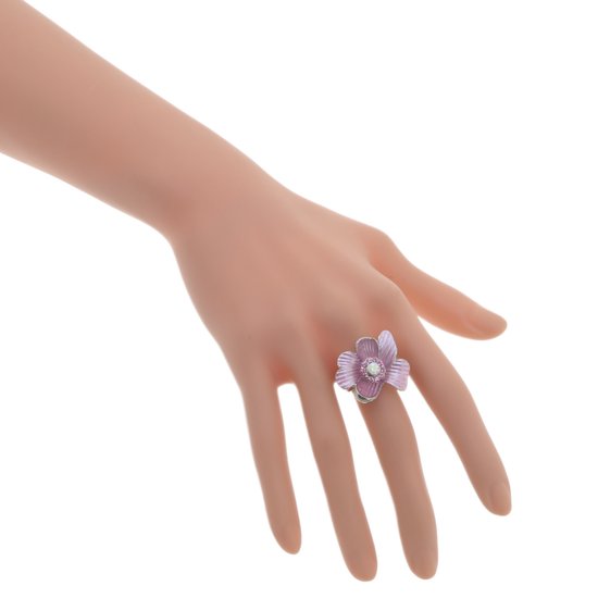 Zilveren ring met lichtroze bloem en parel, gedragen op een hand.