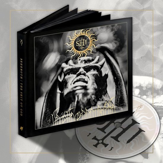 Boek met cd 'The Shit Ov God' van Behemoth. De cover toont een duivels figuur onder een zon met het logo van de band.