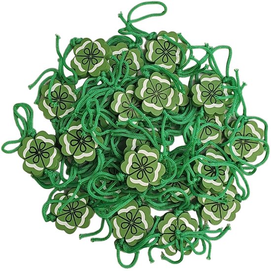 Een hoop groene klavertje vier gelukshangers met touwtjes.