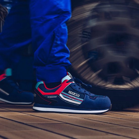 Basses baskets bleues avec accents rouges et bleu clair, logo Sparco Martini Racing sur le côté, sur un plancher en bois.