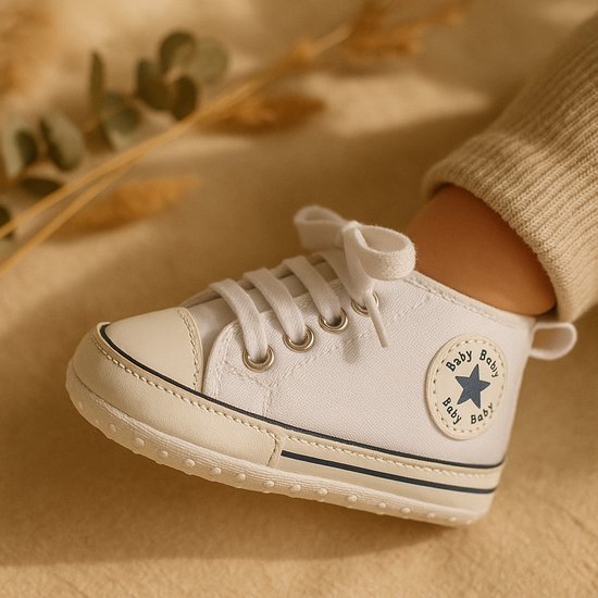 Witte babysneakers met veters en een blauw ster-logo met 'Baby' erop.