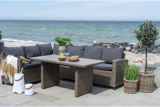 Witte tafel met grijze loungebank, tafel en stoelen, met fleskoeler.