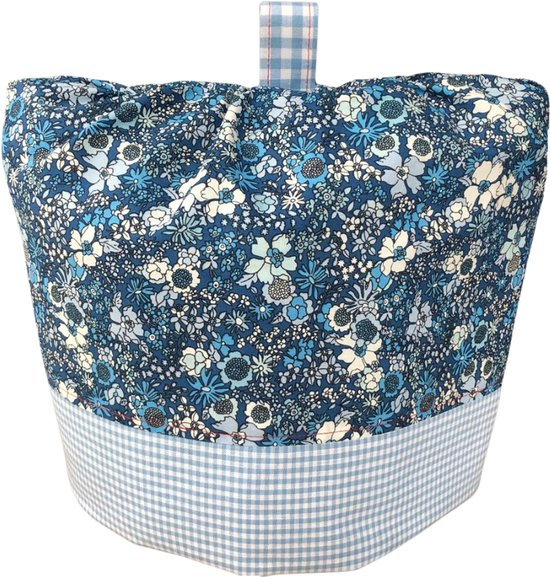 Blauwe theemuts met bloemenprint en een blauw-wit geblokte onderrand. Bovenop een hengsel van geblokt stof.