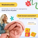 Een vrouw houdt een roze dekbed vast.