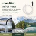 Close-up van een kraan die water spuit, een rivier door een bos en een meer in de bergen. Waterfilter slang is ook zichtbaar.