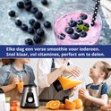 Kinderen kijken hoe orange juice wordt gemixt. Een smoothie met bosbessen staat ernaast.