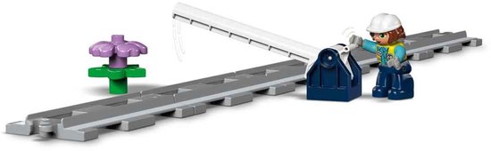 Brug met overweg en bloem. Spoorrails met een blokkeringsboom en een figuur.