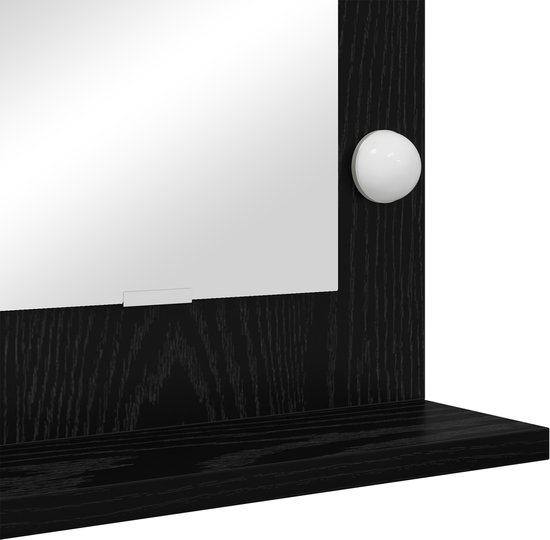 Détail du cadre du miroir noir avec une ampoule et une étagère.