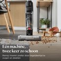 Zwarte BISSELL CrossWave stofzuiger met dweilfunctie, reinigt houten vloer met water en vuil.