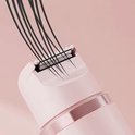 Roze scheerkop van een ladyshave met zwarte haren die erin worden getrokken.