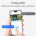 Hand houdt smartphone vast met kind in tuin via camera. Chatballonnen tonen een gesprek.