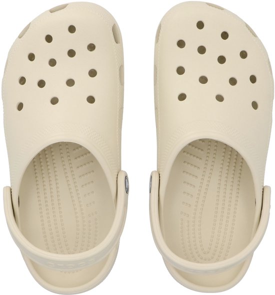 Paar crème Crocs klompen, bovenaanzicht met perforaties en "Crocs" logo op de zool.