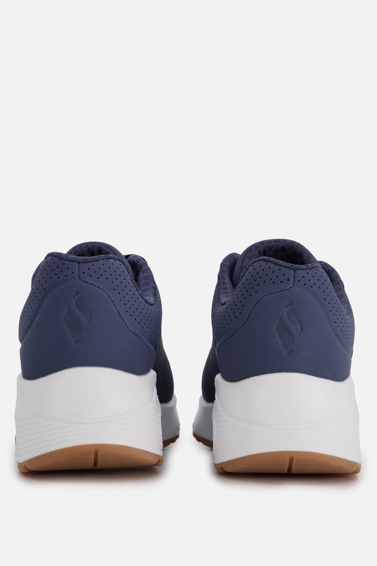 Achterkant van twee blauwe Skechers sneakers met witte zolen en bruine accenten.