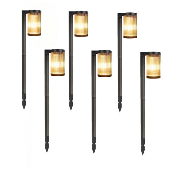 Zes moderne zwarte tuinlampen met geribbelde glazen kap en een puntige staak voor in de grond.
