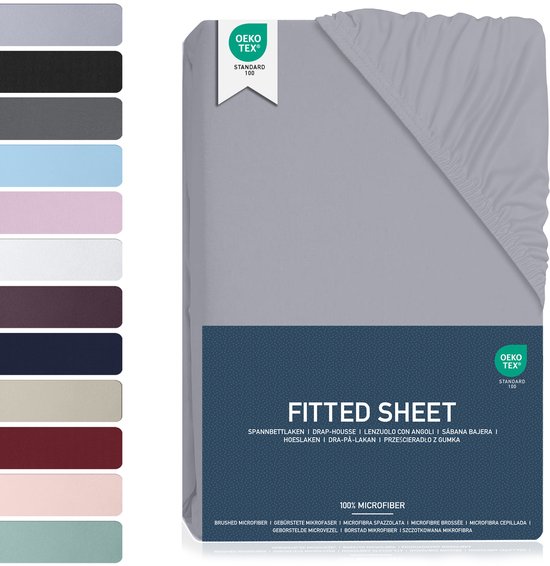 Grijze hoeslaken verpakking met kleurensamples en 'FITTED SHEET 100% MICROFIBER' tekst. OEKO-TEX.