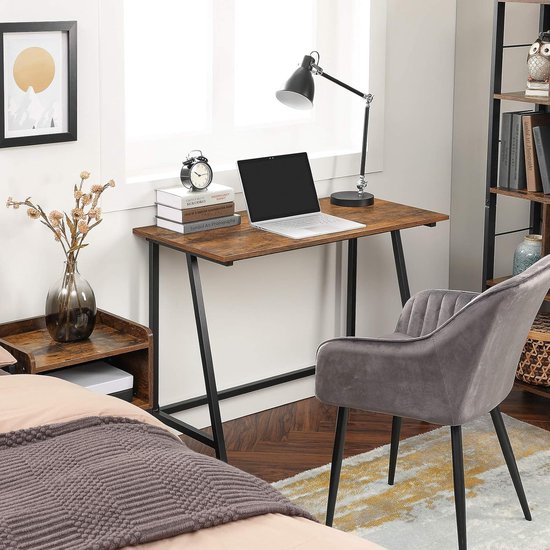 Bureau met bruin houten blad en zwart frame, met een bureaustoel en lamp.