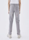 Achterkant van een grijze, aansluitende jeans met opgestikte achterzakken en zwarte stiksels.