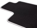Tapis noir avec un passepoil gris ondulé.