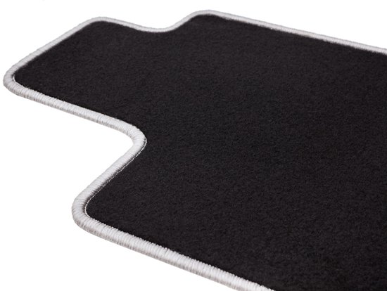 Tapis noir avec un passepoil gris ondulé.