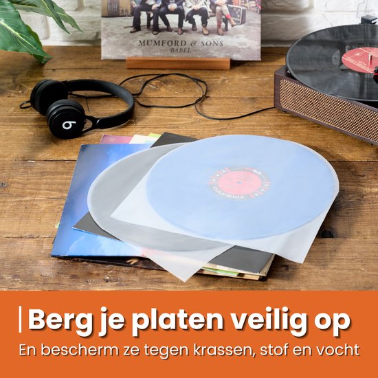 Een stapel LP's en hoezen, met een platenspeler en koptelefoon.