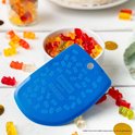 Corne à pâtisserie bleue avec un motif d'oursons Haribo, entourée de bonbons oursons Haribo.