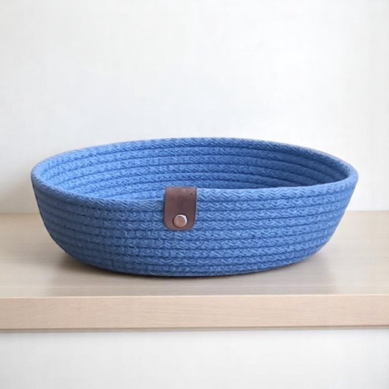 Antiekblauwe mand van gevlochten gerecycled katoen met bruin leren accent.