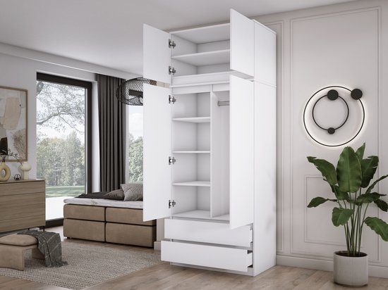 Open witte kledingkast met legplanken en twee lades, in een slaapkamer.