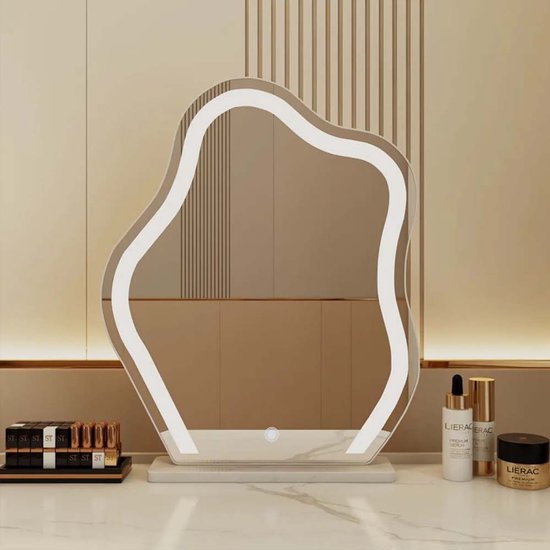 Golvende spiegel met ledverlichting en marmeren basis, geplaatst op een kaptafel met cosmetica.