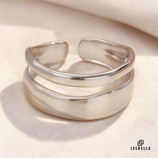Zilverkleurige ring met twee overlappende banden, glanzend afgewerkt.